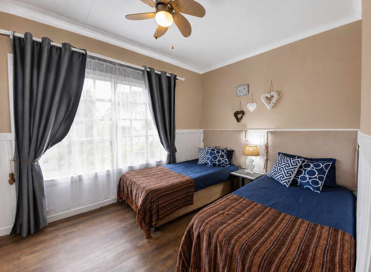 Bright twin bedroom with coastal décor and rattan bedside lamp